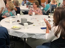 Staff members around a table clapping after a presentation