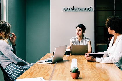 Staff members in a meeting at a conference table.