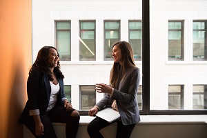 Staff members talking in a window sill. 